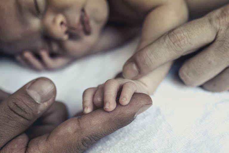 Baby holding parents hands