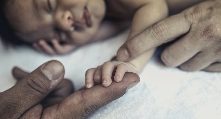 Baby holding parents hands