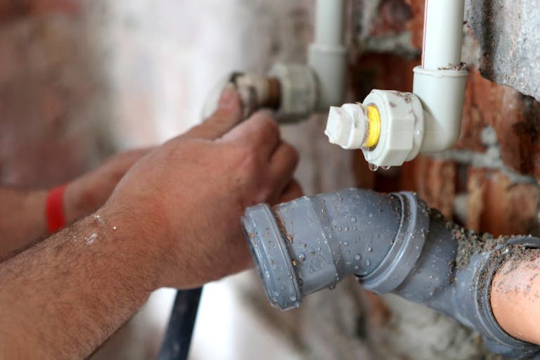 Plumber working on pipes