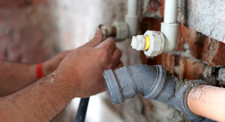 Plumber working on pipes