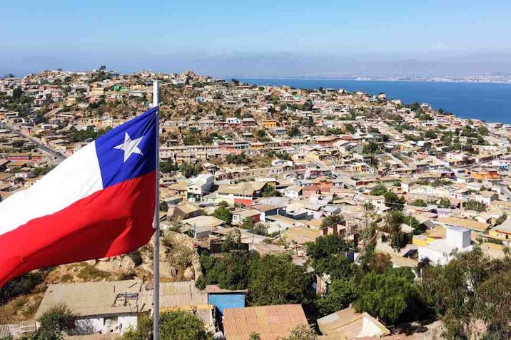 High Angle Shot Of Chile Flag Against Townscape Against Blue Sky