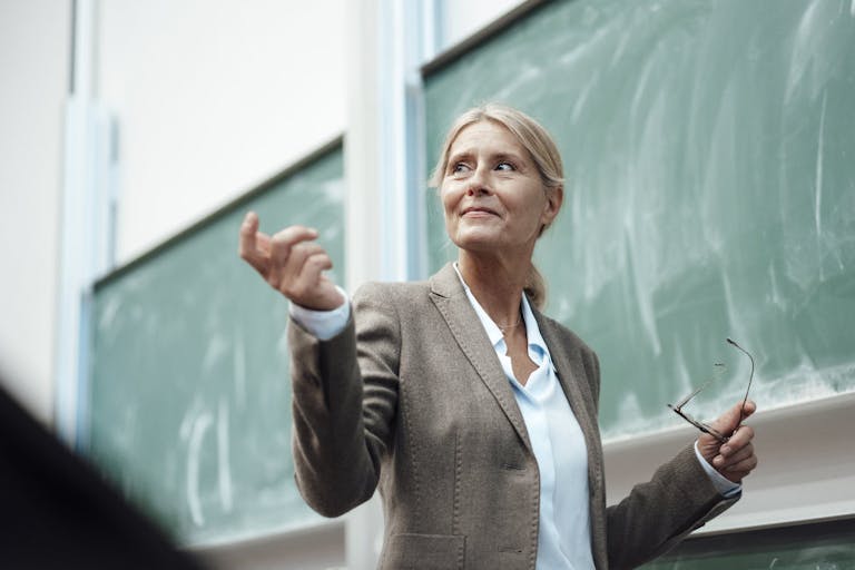 Businesswoman giving presentation by chalkboard at convention center
