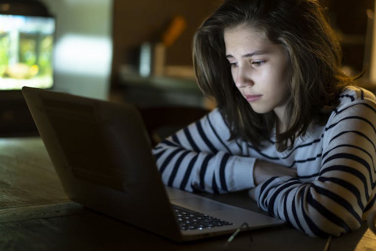 Teenage girl in front of computer late at night