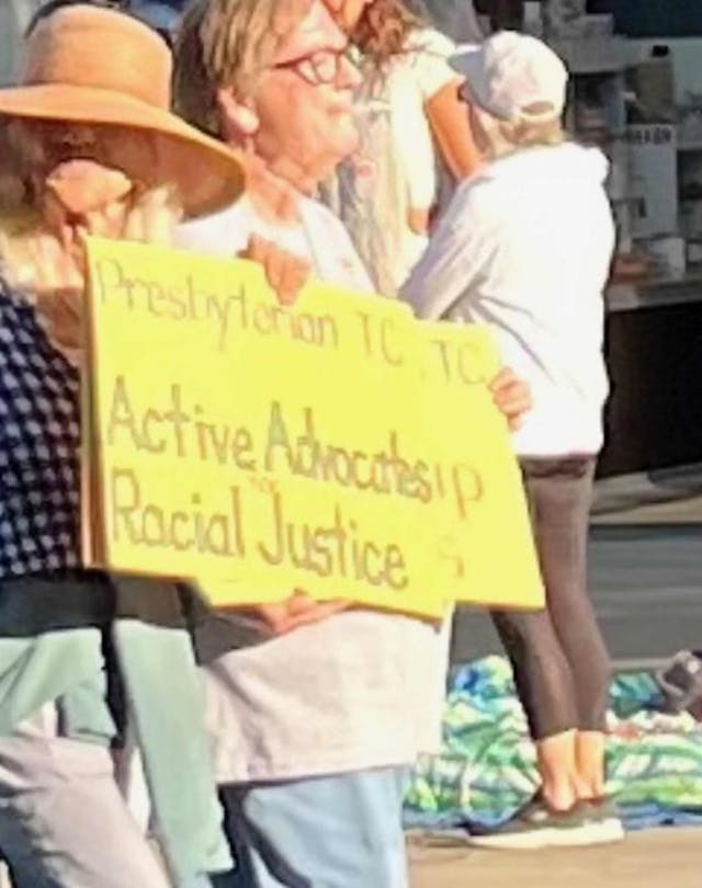 Marchers from a local church display signs calling for “racial justice” in the parade Pro-life teen group uninvited last-minute from National Cherry Festival Parade image