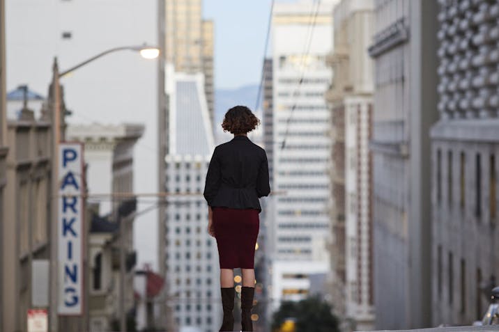 Businesswoman standing on top of steep San Francisco street and looking out
