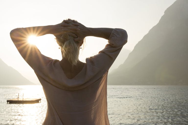 Woman looks out to raft and tranquil mtn lake