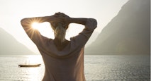 Woman looks out to raft and tranquil mtn lake
