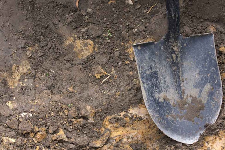 Close-up of spade shovel being used to dig a hole in soil
