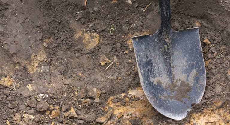 Close-up of spade shovel being used to dig a hole in soil
