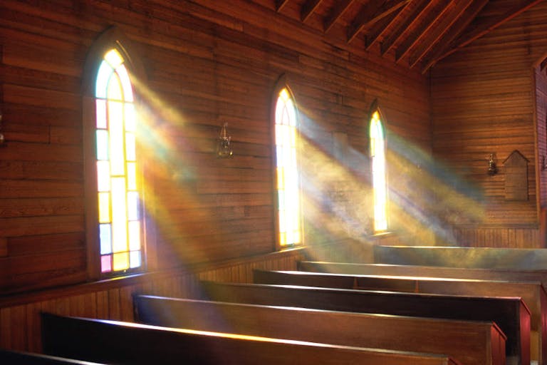 Light streaming through arched windows of church