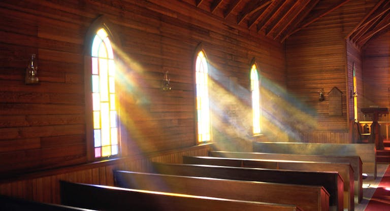 Light streaming through arched windows of church