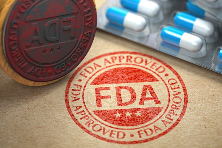 FDA approved  concept. Rubber stamp with FDA and pills on craft paper.