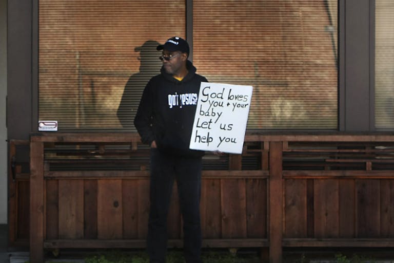 Antiabortion activist Rev. Walter Hoye, stands with his sign in front of an Oakland building where