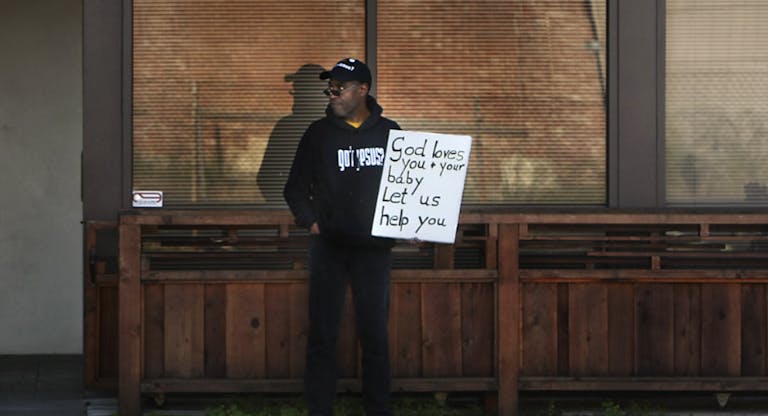 Antiabortion activist Rev. Walter Hoye, stands with his sign in front of an Oakland building where