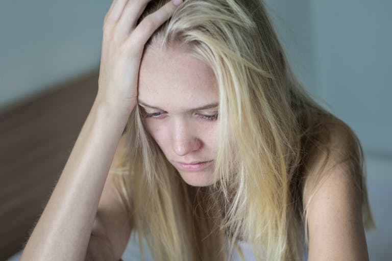 Depressed sad woman in her bed.  Health problems.