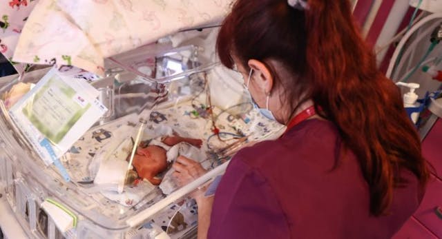 A nurse is taking care of one of the quintuplets laying in an incubator. Krakow, Poland on February 14, 2023. Three girls and two boys were born in the University Hospital, in the 28th week of pregnancy by caesarean section. Polish-British parents have already seven children aged between 10 months and 12 years, and include two pairs of twins. Statistics show that quintuplets are born once in every 52 million pregnancies. (Photo by Beata Zawrzel/NurPhoto via Getty Images) Mom gives birth to preemie quintuplets, one of whom passed away image