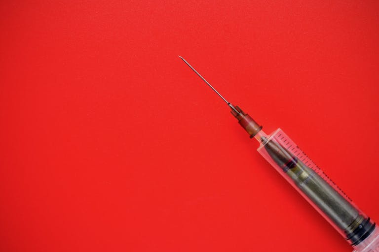 Photo: Iuri Gagarin/Getty Images Bullet in a disposable syringe on a red background