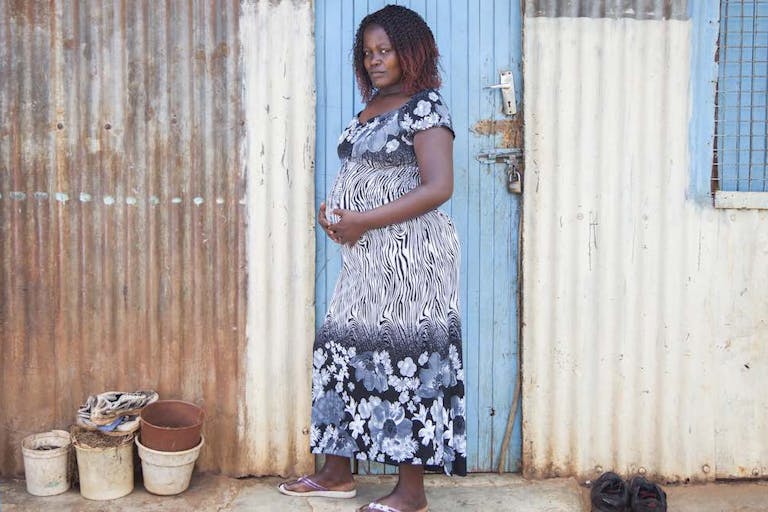 pregnant woman in front of her home