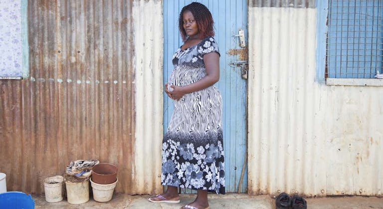 pregnant woman in front of her home