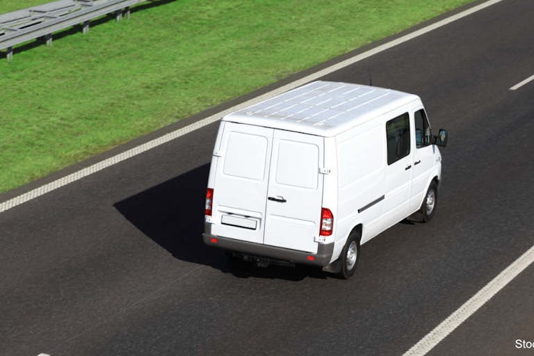 White delivery van driving on a highway