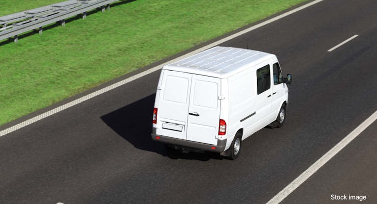 White delivery van driving on a highway