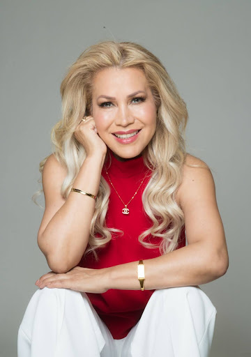 Blonde women in red blouse in front of gray background