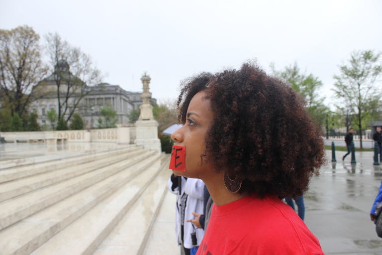 Black woman praying in front of Supreme Court