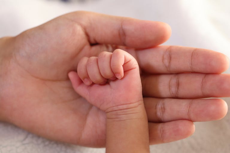 Newborn baby hand in parents hand