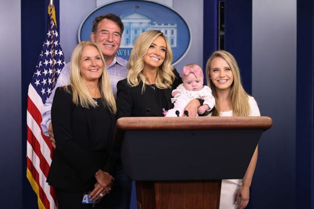WASHINGTON, DC – MAY 01: White House Press Secretary Kayleigh McEnany holds her five-month-old daughter Blake Gilmartin while posing for photographs with her parents Mike and Leanne McEnany and younger sister Ryann McEnany at the podium in the Brady Press Briefing Room at the White House May 01, 2020 in Washington, DC. Friday was McEnany’s first official news conference since becoming President Donald Trump’s fourth press secretary in just over three years. (Photo by Chip Somodevilla/Getty Images) WASHINGTON, DC – MAY 01: White House Press Secretary Kayleigh McEnany holds her five-month-old daughter Blake Gilmartin while posing for photographs with her parents Mike and Leanne McEnany and younger sister Ryann McEnany at the podium in the Brady Press Briefing Room at the White House May 01, 2020 in Washington, DC. Friday was McEnany’s first official news conference since becoming President Donald Trump’s fourth press secretary in just over three years. (Photo by Chip Somodevilla/Getty Images)