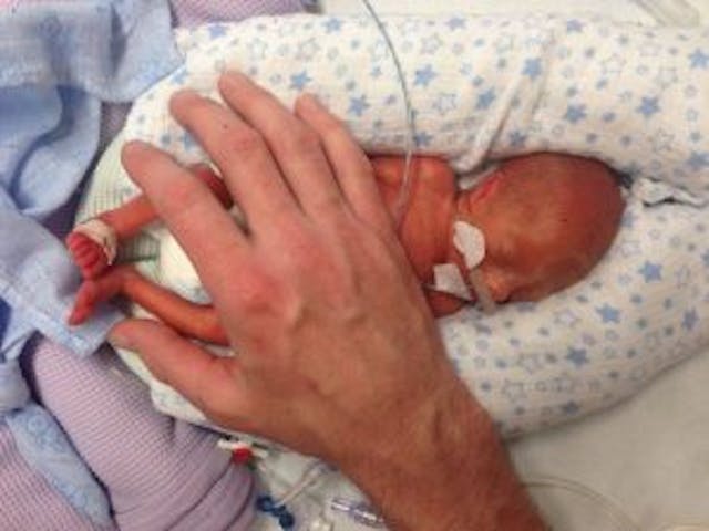 Paul Morris places his hand on his 10-day-old son Jett. photo via facebook