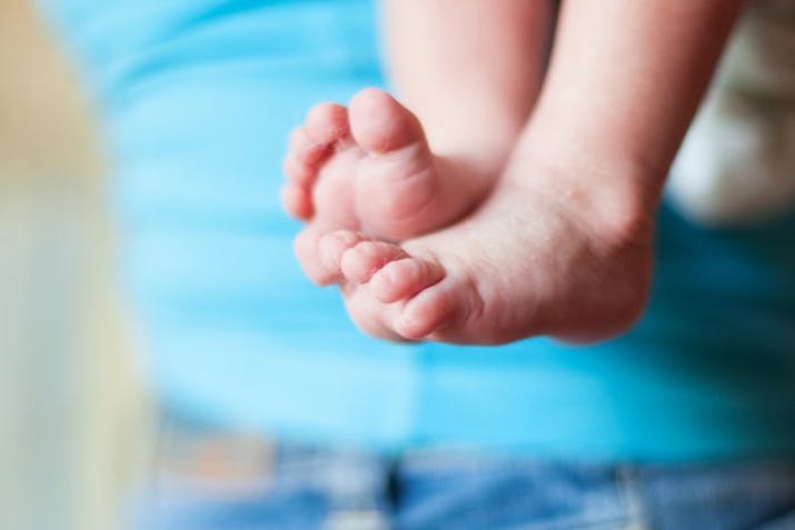 A baby's feet with a blue background