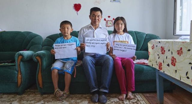 BAIDIBEK, KAZAKHSTAN – JULY 27, 2018: Uali Islam and his two children, hold signs calling for the release of his wife, Sayragul Sauytbay, who fled China after being forced to work in a internment camp in China’s far north west. On Aug. 1, a court ruled she will be reunited with her family, not deported back to China. (Photo by Izturgan Aldauev/For The Washington Post via Getty Images) BAIDIBEK, KAZAKHSTAN – JULY 27, 2018: Uali Islam and his two children, hold signs calling for the release of his wife, Sayragul Sauytbay, who fled China after being forced to work in a internment camp in China’s far north west. On Aug. 1, a court ruled she will be reunited with her family, not deported back to China. (Photo by Izturgan Aldauev/For The Washington Post via Getty Images)