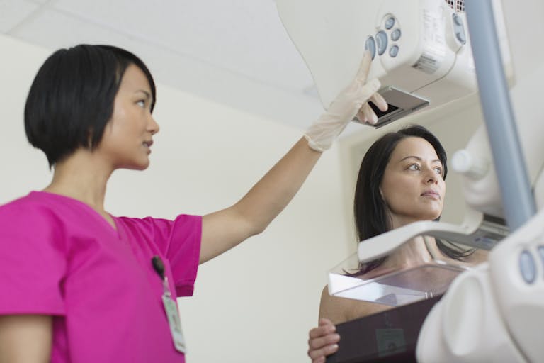 technician with patient having a mammograph