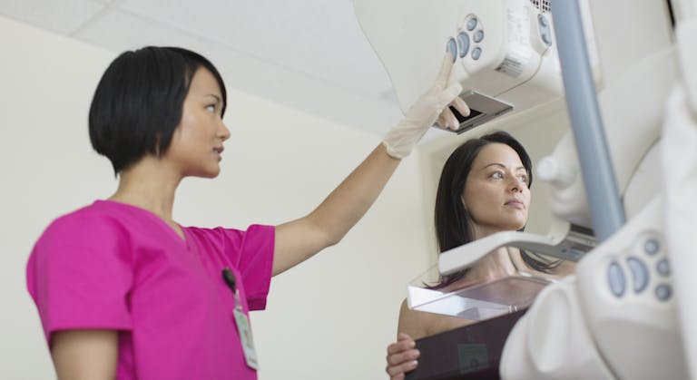 technician with patient having a mammograph