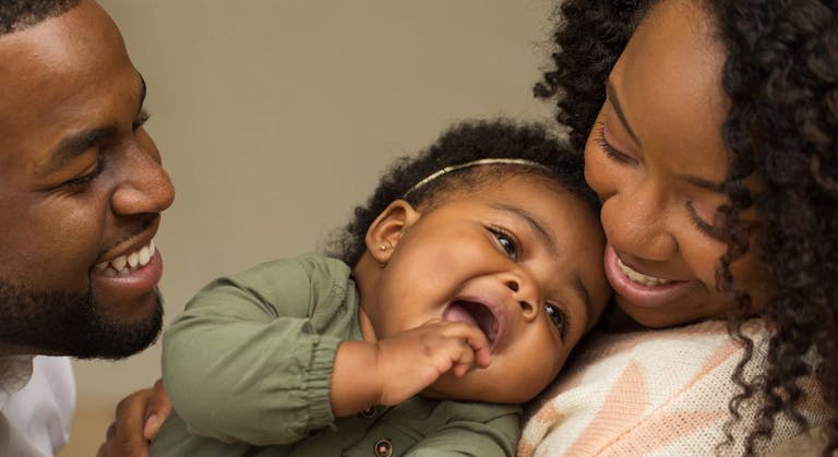 Happy African American family with their little girl.