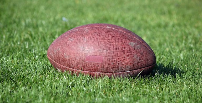 Football in grass. Licensed from Dreamstime.