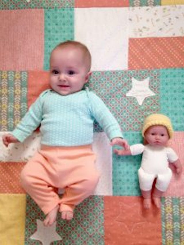 Naomi and a doll wearing Naomi’s NICU hat. Photo courtesy of Angela Bakker. Naomi and a doll wearing Naomi's NICU hat. Photo courtesy of Angela Bakker.