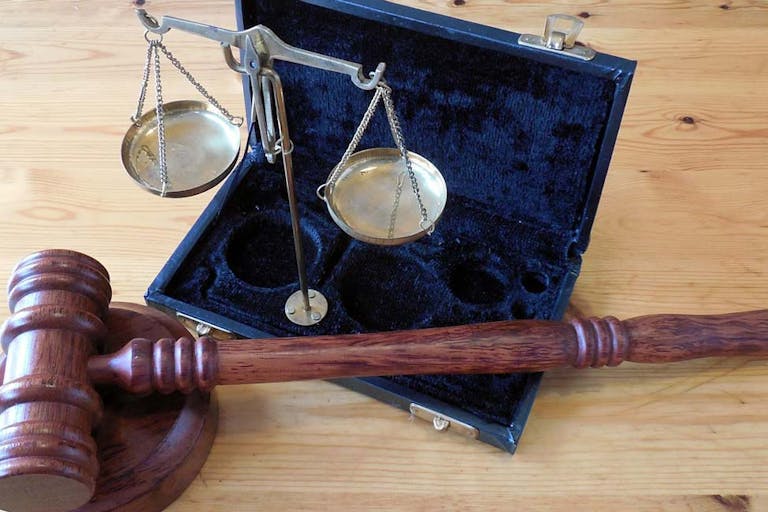 judge gavel and scale sit on a tabletop