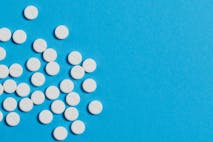 White pills scattered on a blue background.