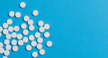 White pills scattered on a blue background.
