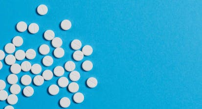 White pills scattered on a blue background.