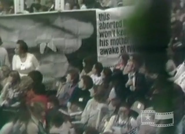 Pro-life women object to abortion resolution carry banner of 10 week aborted baby at 1977 Women’s conference in Houston Prolife women object to abortion resolution carry banner