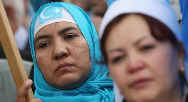 A Muslim woman wears an East Turkistan flag at a demonstration by ethnic Uighurs and other protesters against suppression of Uighurs in China near the Chinese embassy on July 10, 2009 in Berlin, Germany. (Photo by Sean Gallup/Getty Images) Uighur Muslims, China