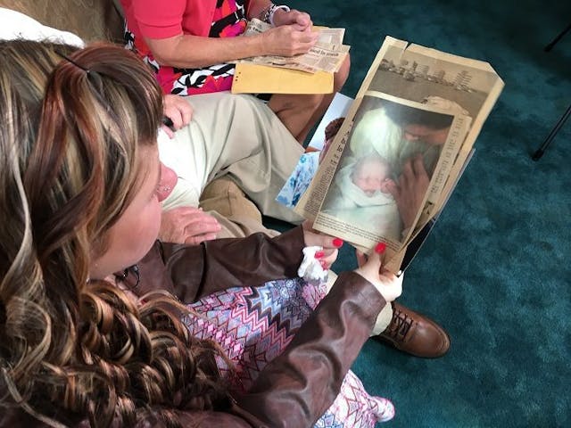 Morgan looks at a photo of her as a newborn when she was found in a dumpster. Photo courtesy of Morgan Hill. No one even knew Morgan's mother was pregnant.
