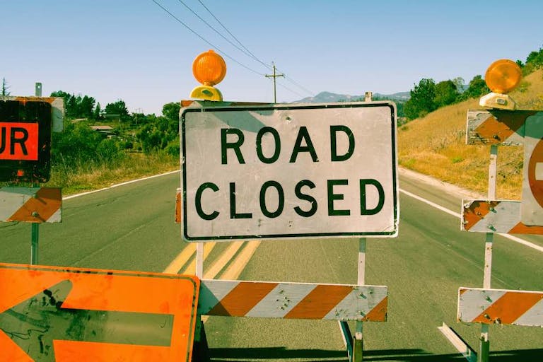 Close up row of road closed signs on highway
