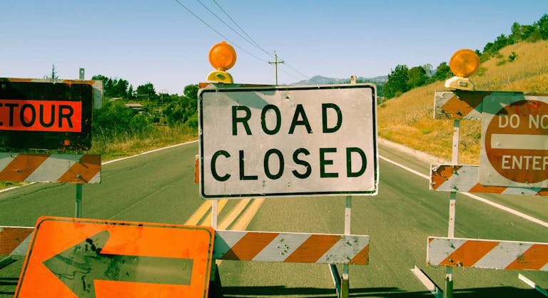 Close up row of road closed signs on highway