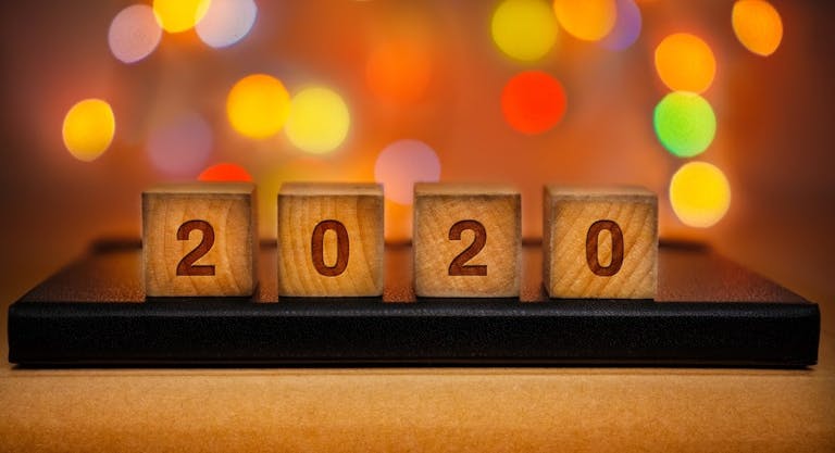 2020 Text on Wood Block Against Abstract Colorful Illuminated Defocused Bokeh Lights Background.