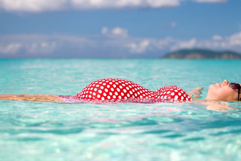 pregnant woman floating on water at the Caribbean beach