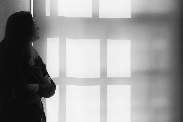 Thoughtful Woman With Arms Crossed Looking At Wall