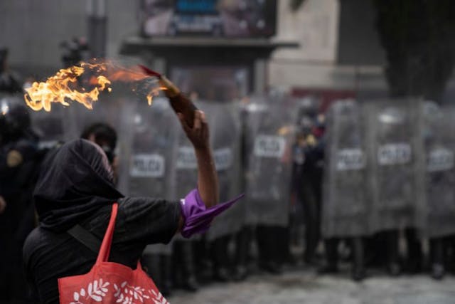 MEXICO CITY, MEXICO – SEPTEMBER 28: A protester throws a molotov cocktail at police officers during a demonstration in favor of the decriminalization of abortion on the International Safe Abortion Day on September 28, 2020 in Mexico City, Mexico. In Mexico, only two states allow legal abortions in women up to twelve weeks of pregnancy. (Photo by Toya Sarno Jordan/Getty Images) Abortion advocates in Mexico City violently clash with police over pro-life laws image